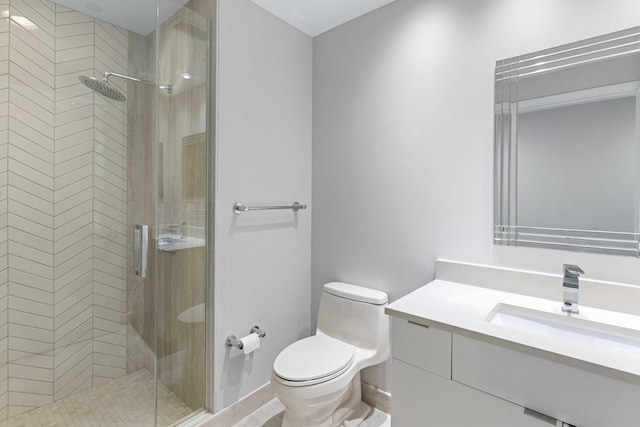 bathroom with toilet, a stall shower, and vanity