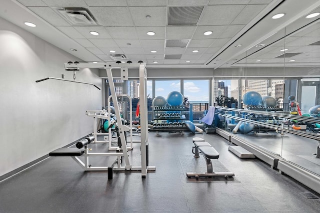 workout area featuring a paneled ceiling, a view of city, and visible vents