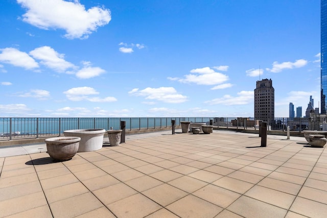 view of patio / terrace featuring a water view and a view of city