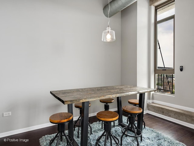 dining room with wood-type flooring, baseboards, and a healthy amount of sunlight