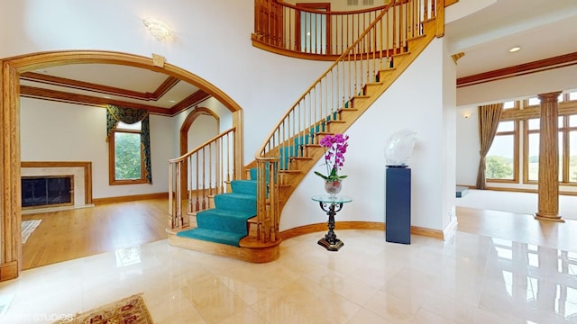 staircase featuring baseboards, ornamental molding, and a healthy amount of sunlight