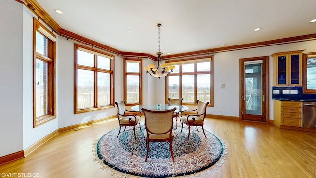 dining space featuring ornamental molding, baseboards, a notable chandelier, and light wood-type flooring
