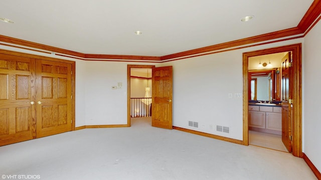 unfurnished bedroom with baseboards, visible vents, a sink, and carpet flooring