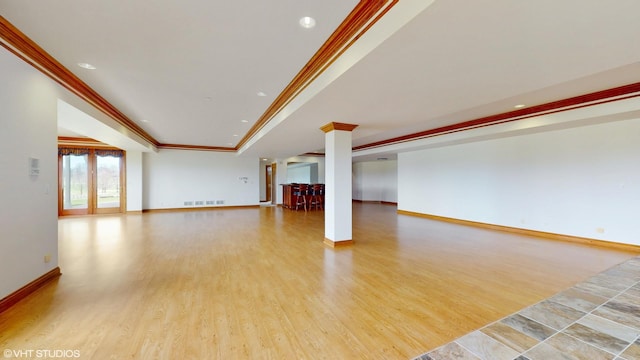 unfurnished living room with recessed lighting, light wood finished floors, baseboards, visible vents, and crown molding