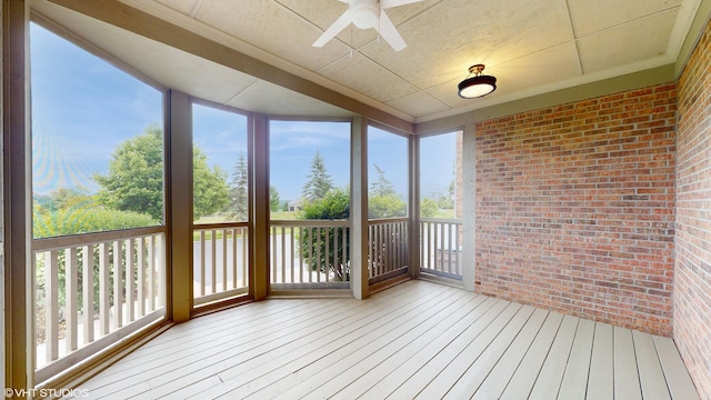unfurnished sunroom featuring ornamental molding, wood-type flooring, and a healthy amount of sunlight