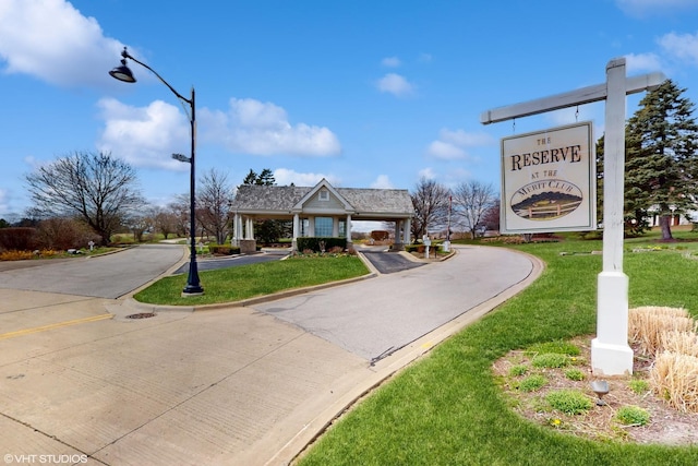 surrounding community featuring aphalt driveway and a yard