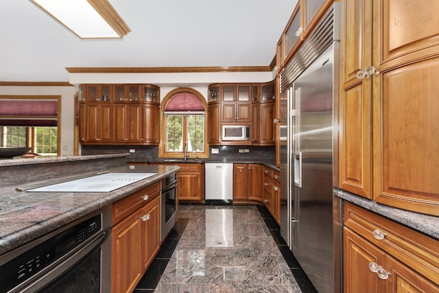 1020 Evergreen Dr, Lake Forest, IL 60045 - kitchen featuring stainless steel appliances, brown cabinets, ornamental molding, glass insert cabinets, and dark countertops