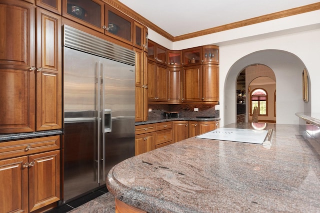 1020 Evergreen Dr, Lake Forest, IL 60045 - kitchen with stainless steel built in fridge, arched walkways, electric stovetop, tasteful backsplash, and glass insert cabinets