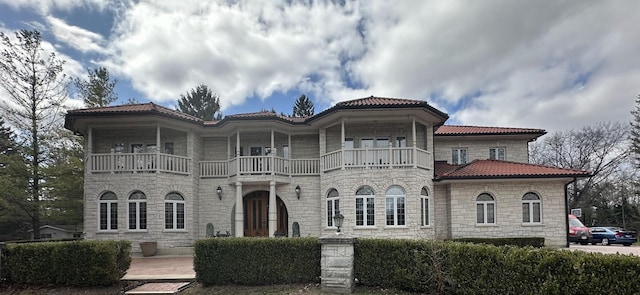 1020 Evergreen Dr, Lake Forest, IL 60045 - view of front of house with a balcony, stone siding, and a tile roof