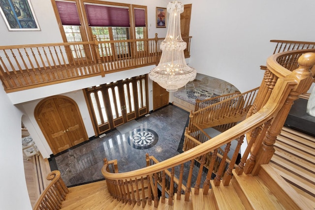 1020 Evergreen Dr, Lake Forest, IL 60045 - stairway with wood finished floors, a chandelier, and a towering ceiling