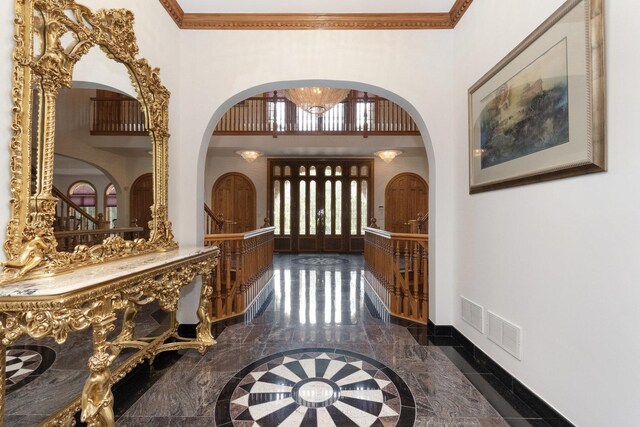 1020 Evergreen Dr, Lake Forest, IL 60045 - foyer with marble tiled floors, arched walkways, a high ceiling, inlaid floor details, and baseboards