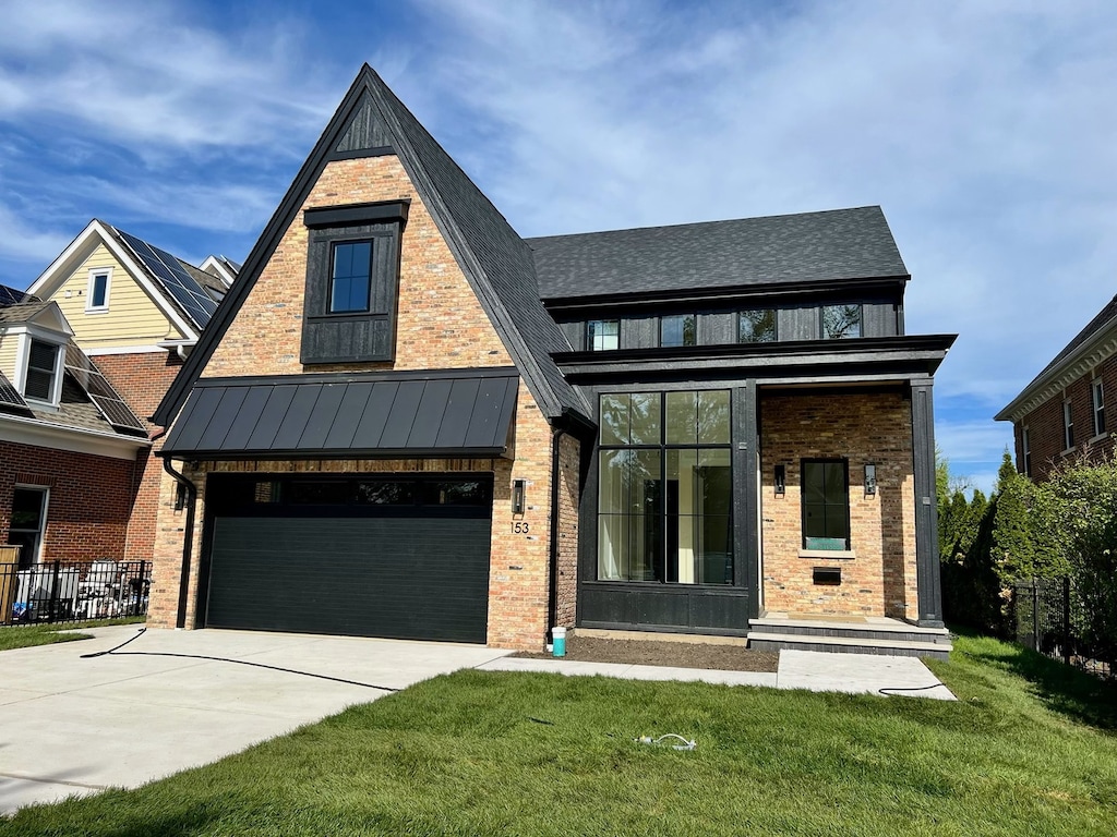view of front of property featuring concrete driveway, brick siding, a garage, a standing seam roof, and metal roof
