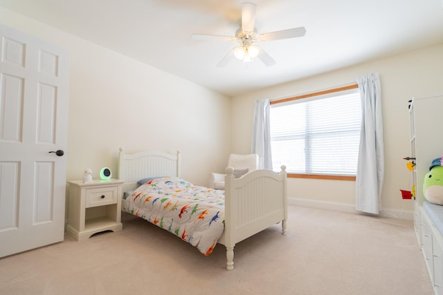 bedroom featuring ceiling fan, light carpet, and baseboards