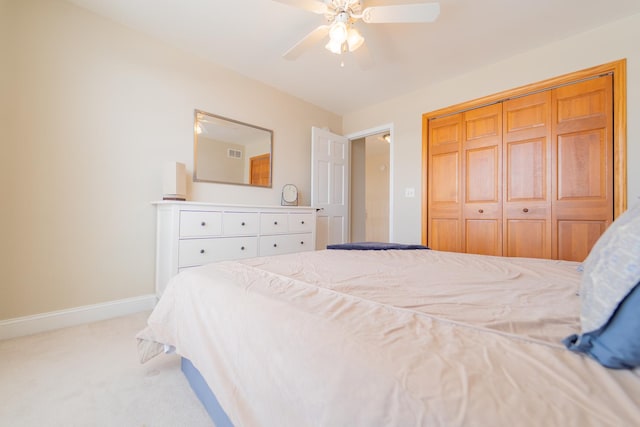 bedroom featuring ceiling fan, baseboards, a closet, and light colored carpet