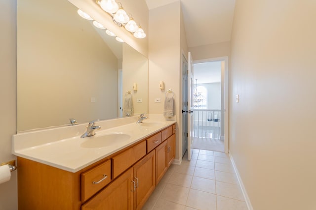 bathroom featuring double vanity, tile patterned floors, baseboards, and a sink