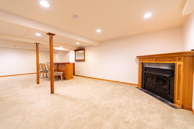 finished basement with recessed lighting, a fireplace with flush hearth, baseboards, and light colored carpet