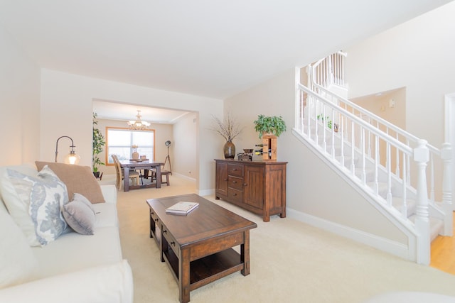 living area with baseboards, light colored carpet, an inviting chandelier, and stairway