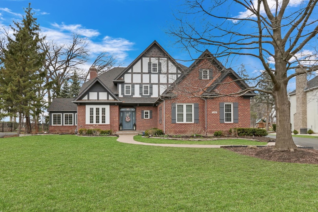 7188 Brae Ct, Gurnee, IL 60031 - english style home with roof with shingles, a chimney, a front yard, and brick siding