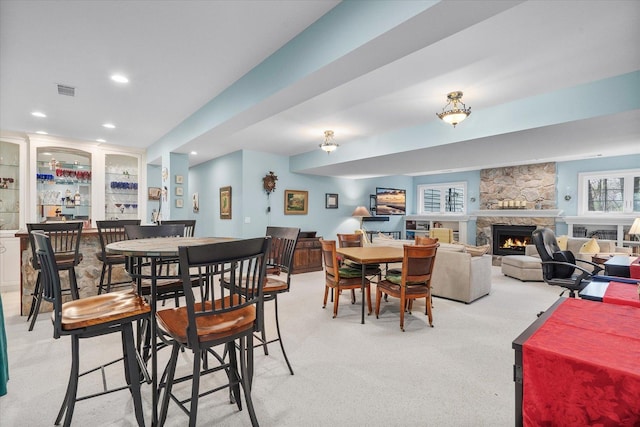 dining room with visible vents, a fireplace, recessed lighting, light colored carpet, and bar area