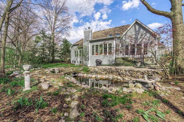 back of house featuring a chimney