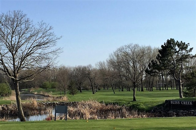 view of property's community featuring a lawn and a water view