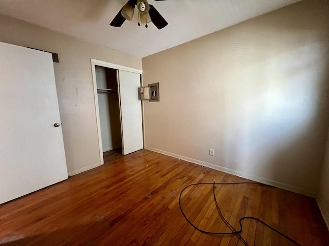 1101 N Coler Ave, Urbana, IL 61801 - unfurnished bedroom with wood finished floors, a closet, a ceiling fan, baseboards, and electric panel