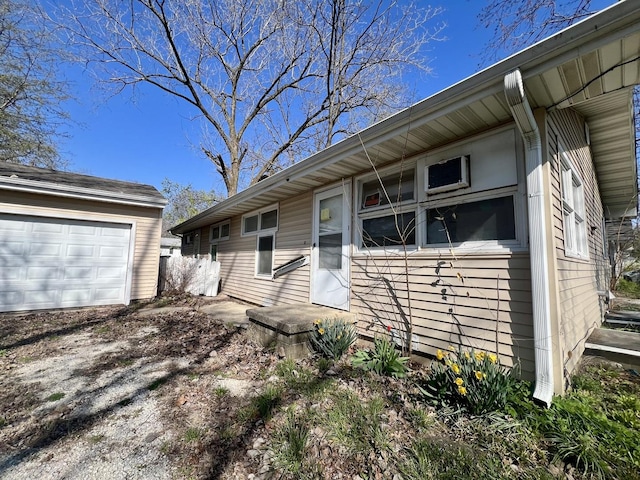 1101 N Coler Ave, Urbana, IL 61801 - view of front facade with a garage, dirt driveway, and an outbuilding