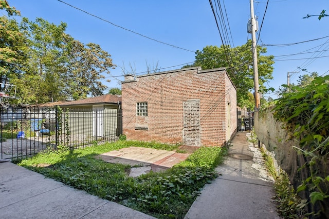 view of side of home with brick siding and fence