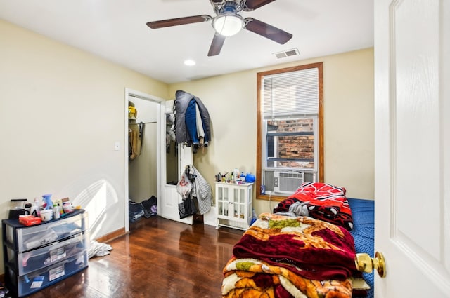 bedroom with cooling unit, ceiling fan, visible vents, and wood finished floors