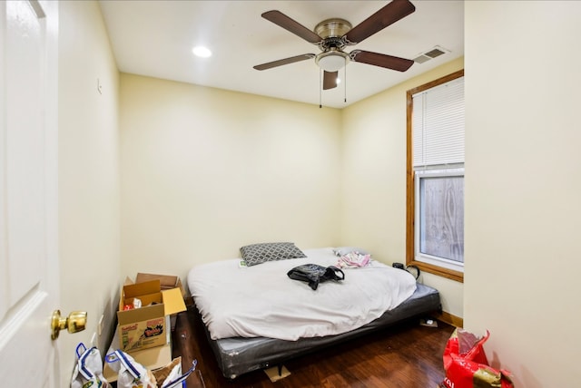 bedroom with wood finished floors, baseboards, ceiling fan, and visible vents