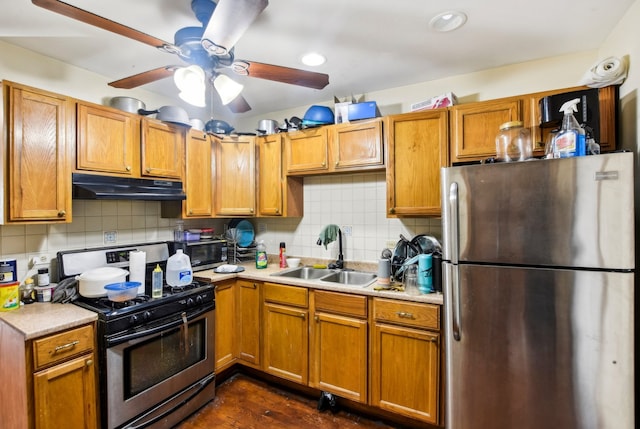 kitchen featuring under cabinet range hood, light countertops, a sink, and appliances with stainless steel finishes