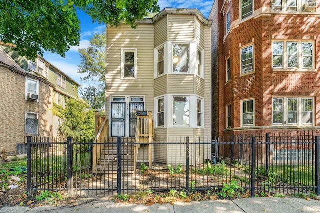 townhome / multi-family property with cooling unit and a fenced front yard