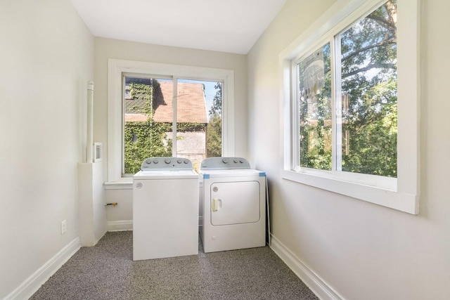 clothes washing area featuring independent washer and dryer, laundry area, and baseboards