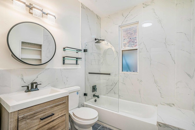 bathroom featuring tile walls, bathing tub / shower combination, toilet, and vanity