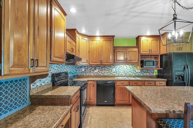 kitchen with a sink, brown cabinetry, range hood, and black appliances