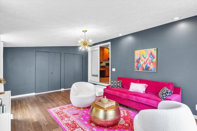 living room with an inviting chandelier, wood finished floors, and baseboards