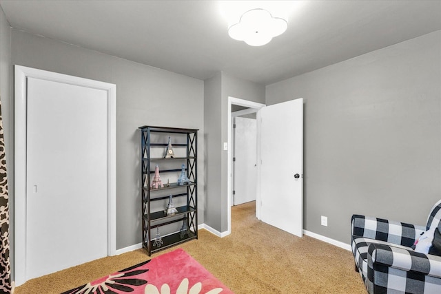 bedroom with light colored carpet and baseboards