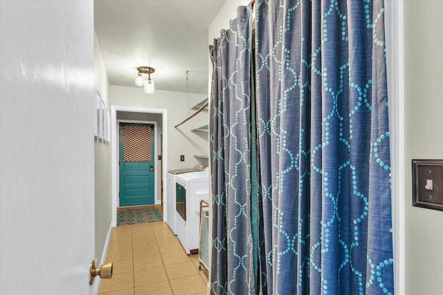 bathroom with washing machine and clothes dryer, tile patterned flooring, and baseboards
