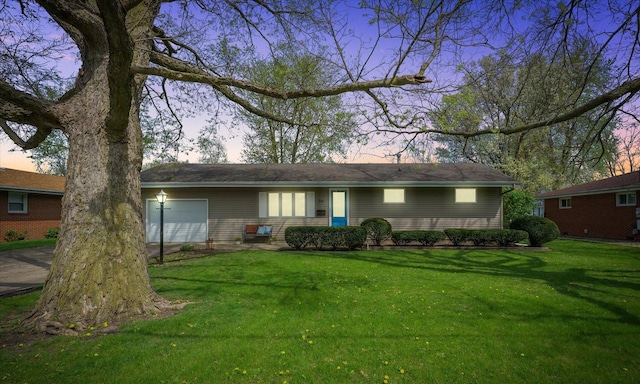 view of front of home with concrete driveway, a front yard, and a garage