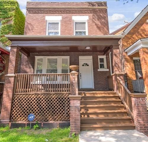 property entrance with covered porch and brick siding