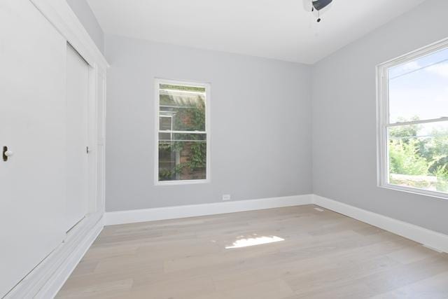 spare room featuring baseboards and light wood-type flooring