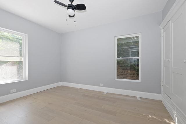 spare room with baseboards, ceiling fan, and light wood-type flooring