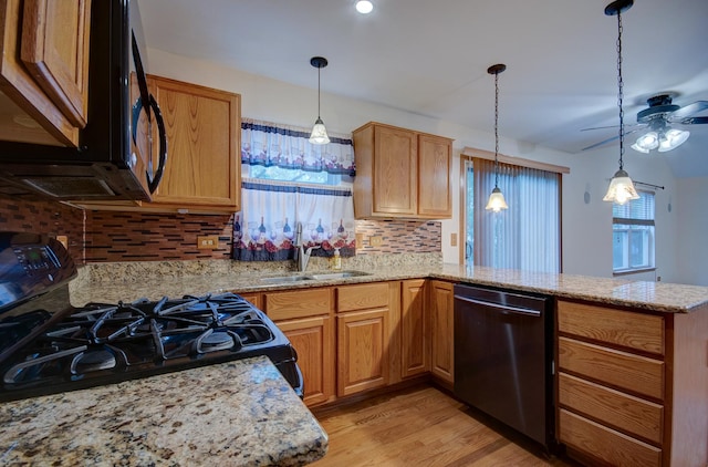 5615 Cider Grove Ct, Plainfield, IL 60586 - kitchen with black appliances, a sink, a peninsula, backsplash, and light wood-style floors