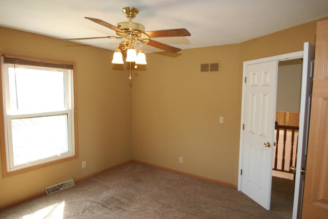 801 Heritage Dr, Mackinaw, IL 61755 - carpeted empty room with baseboards, visible vents, and a ceiling fan