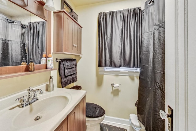 bathroom featuring baseboards, curtained shower, toilet, and vanity