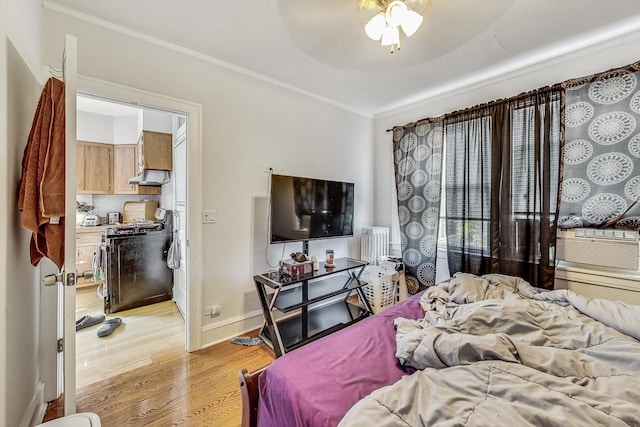 bedroom featuring crown molding, baseboards, radiator heating unit, light wood-style floors, and cooling unit