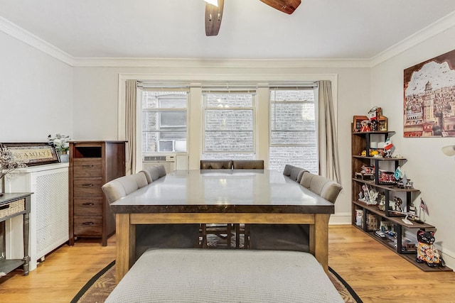 dining space with a ceiling fan, crown molding, and light wood-type flooring