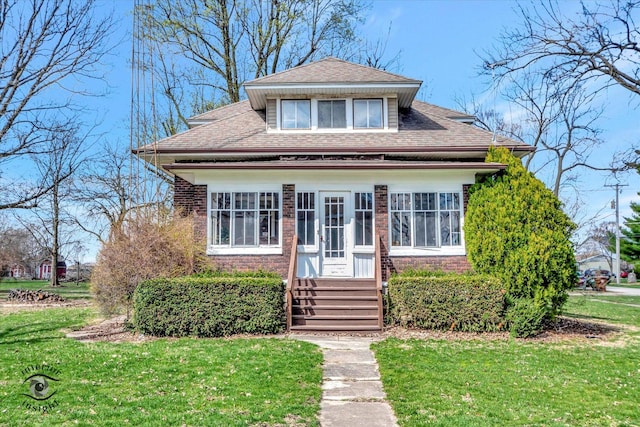 bungalow-style house featuring a front yard, entry steps, and roof with shingles