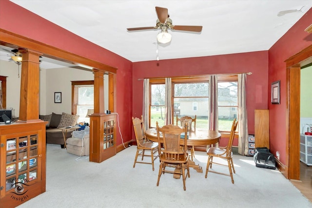dining space with light colored carpet, decorative columns, and ceiling fan