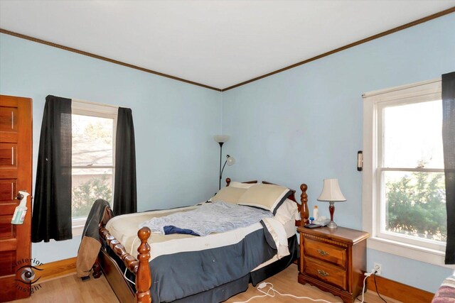 bedroom featuring ornamental molding and light wood-style flooring